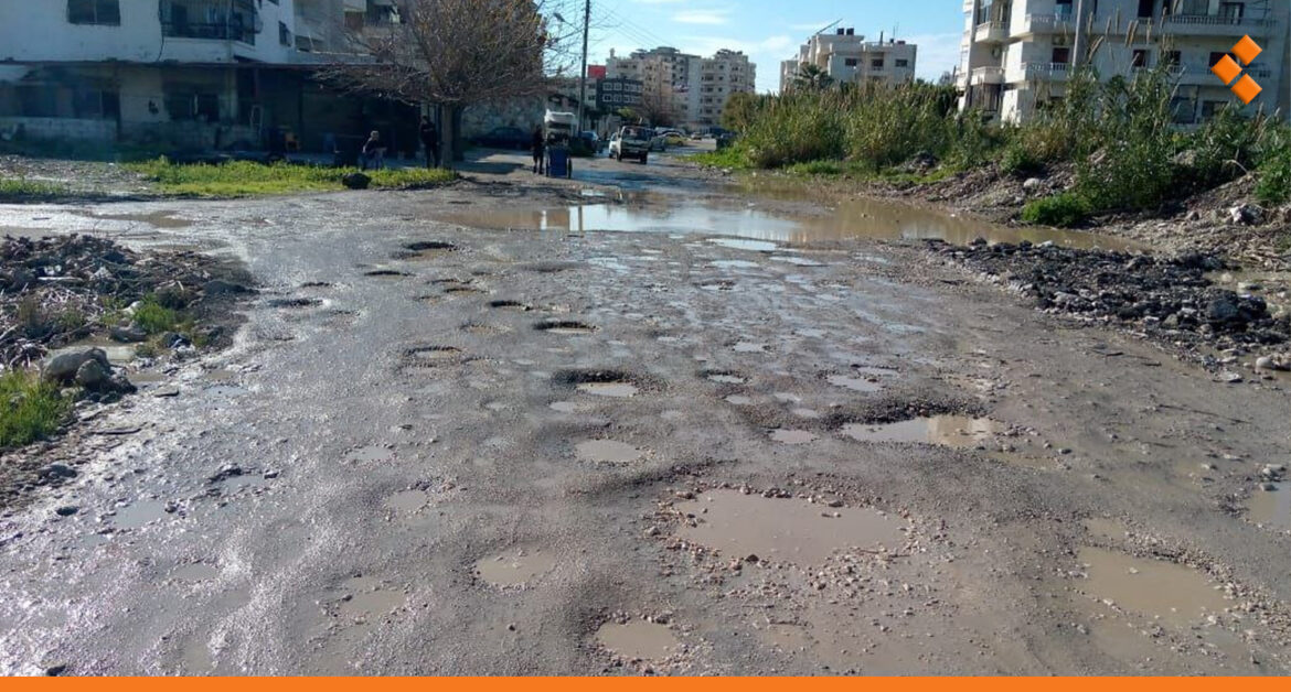 الحُفر وبرك الماء تطغى على طريق بحي المشروع العاشر في اللاذقية و"الحل" بعد شهرين